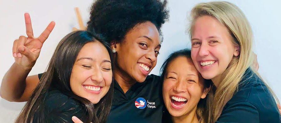 Four Peace Corps volunteers smiling